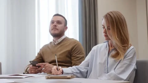 Female worker writing down notes at a meeting, sitting on a chair Vídeo Stock 218615230