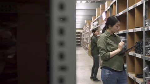 Female workers in warehouse use digital tablet Stock Footage 131795154