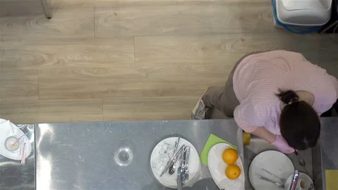 Female working at the kitchen table in a restaurant. Video stock 123919364