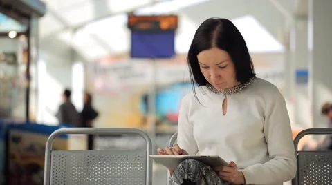 The female is working with tablet pc waiting in airport hall Stock Footage 65742414