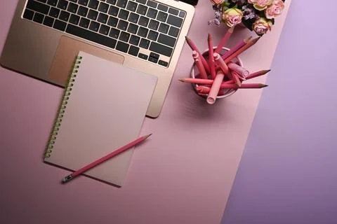 Female workspace with computer laptop, notebook, pencil holder and flowers on Stock Photos