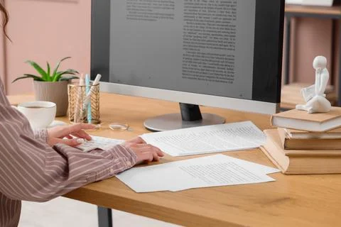 Female writer editing text on computer before publishing in office Stock Photos