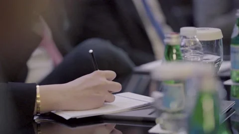 Female writing notes on a small notepad in meeting room Stock Footage 163742377
