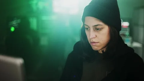 Female young hacker working on computer in dark room programming code Stock Footage 310505664