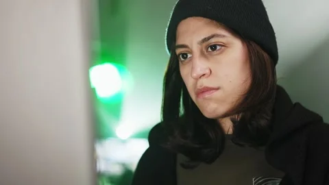 Female young hacker working on computer in dark room programming code Stock Footage 310505783