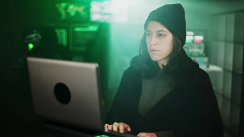 Female young hacker working on computer in dark room programming code Stock Footage 310505870
