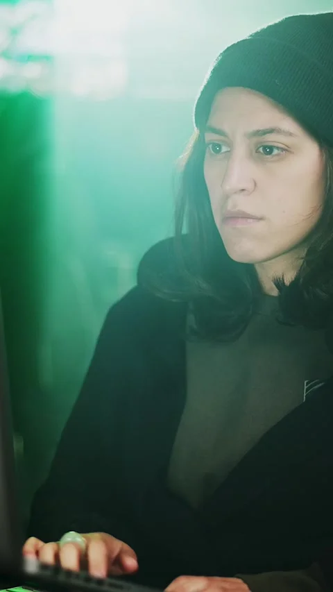 Female young hacker working on computer in dark room programming code Stock Footage 316792660