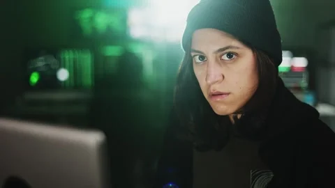 Female young hacker working on computer in dark room programming code Stock Footage 316809236