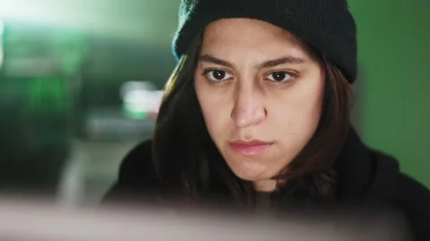 Female young hacker working on computer in dark room programming code Stock Footage 316809244
