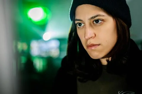 Female young hacker working on computer in dark room programming code Foto stock