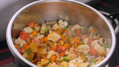 Female/chef adding a spoon full of salt in pot of mixed vegetables Stock Footage 114055099