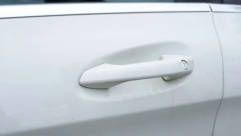 Female's hand opens modern white car door by grabbing its handle. Stock Footage 100787366