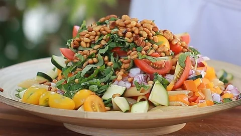 Female's hands cook spread pine nuts vegan vegetable salad Stock Footage 73654299