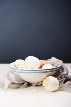 Feminine Easter concept. White eggs in bowl. Dark background. Foto stock