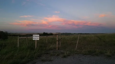 Fence and purple pink clouds over the Prairie Stock Footage 219596576