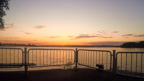 Fence and trees on the pond at sunset in summer 스톡 동영상 82370461