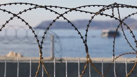 A fence with barbed wire amid a sailing ship in the Mediterranean Sea Stock-Footage 118547384