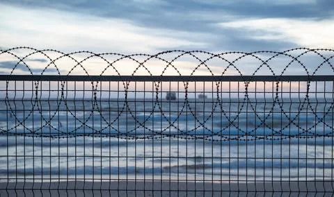   Fence barbed wire and ship in the background Stock Photos