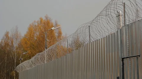 A fence with barbed wire around the Russian prison Stock Footage 91779656