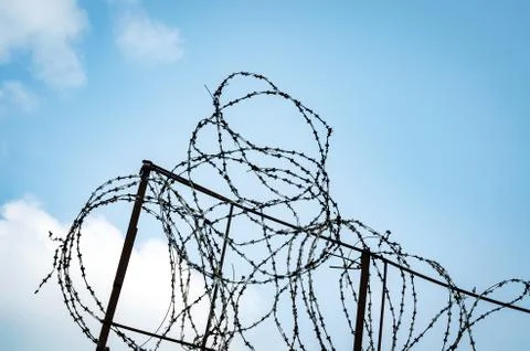 A Fence With Barbed Wire On A Background Of Blue Sky With Vignette Stock Photos
