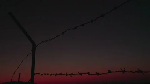 Fence with barbed wire on a background of sunset and night sky. Stock Footage 132632945