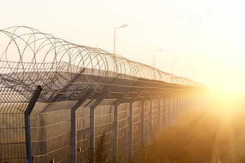 Fence with barbed wire on the border Stock Photos