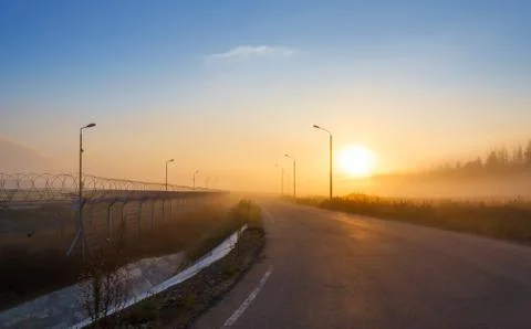 Fence with barbed wire on the border Stock Photos