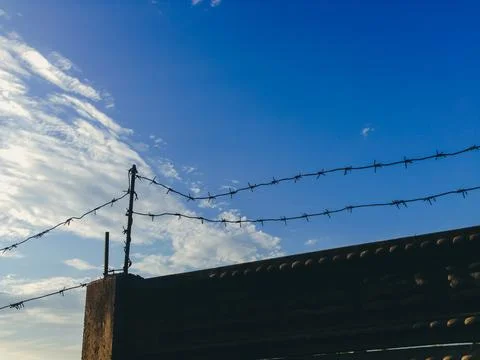 A fence with barbed wire is on a bridge Stock Photos