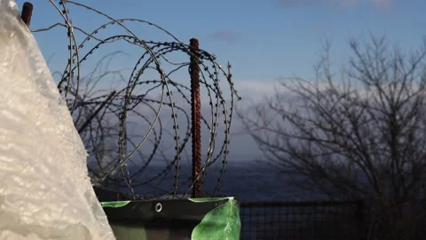 A fence with barbed wire. Close-up. Guarded restricted area. Border on the coast Stock Footage 146929342