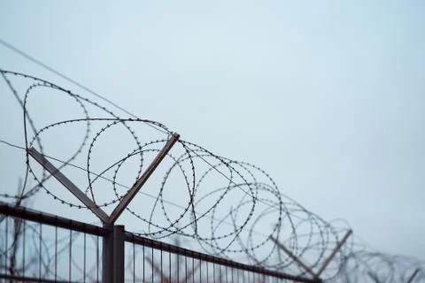 Fence with barbed wire. focus with shallow depth of field. Stock Photos