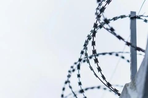 Fence with barbed wire. focus with shallow depth of field. Stock Photos