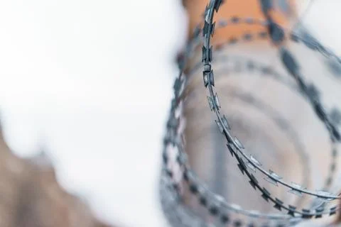 Fence with barbed wire. focus with shallow depth of field. Stock Photos