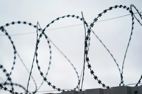 Fence with barbed wire. focus with shallow depth of field. Stock Photos