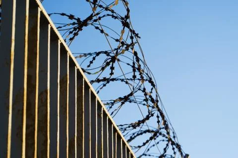 Fence with barbed wire. focus with shallow depth of field. Stock Photos