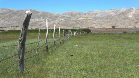 Fence with barbed wire in the middle of highland Stock Footage 166054299