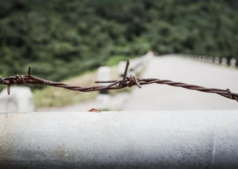 Fence with a barbed wire Stock Photos