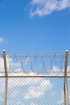 Fence with a barbed wire Stock Photos
