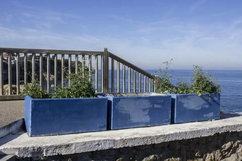 A fence on a cliff by the ocean. Stock Photos