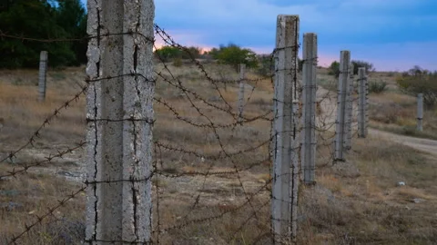 The fence of concrete pillars and rusty barbed wire. Stock Footage 98028092