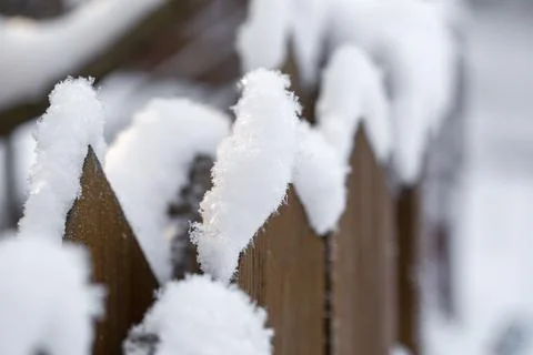 Fence covered with snow in the sunlight Stock Photos
