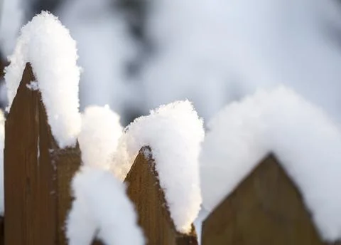 Fence covered with snow in the sunlight Stock Photos