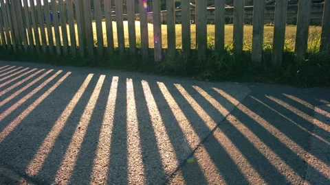 Fence dappled light at sunset dusk Video stock 344747573