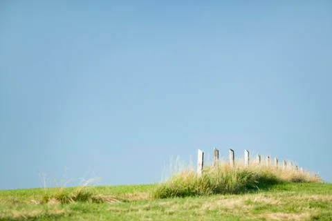 Fence ending in the middle of field Stock Photos