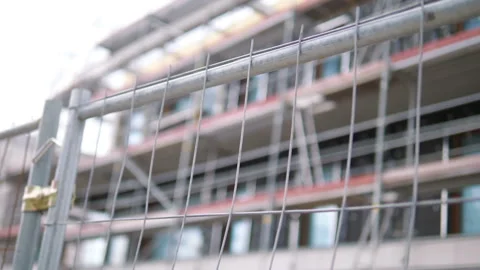 Fence in front of the construction of a modern building in slow motion 180fps Stock Footage 155531470