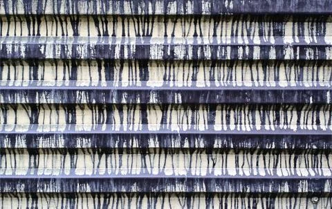 The fence is made of corrugated tin with multiple stains of paint. Texture. G Stock Photos
