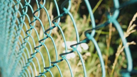 A fence made of metal mesh on the background of nature in a blur Stock Footage 219934054