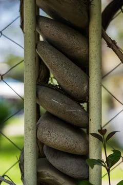 A fence made of stones. A column of round stones Stock Photos