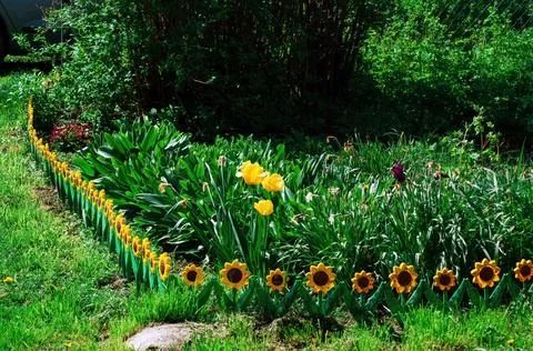 Fence of plastic flowers in spring Stock Photos