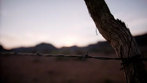 Fence post against beautiful sunset and mountains in the desert Stock Footage 154912120