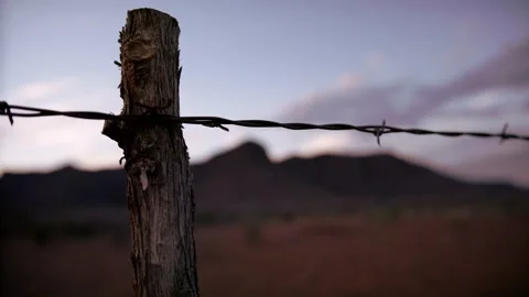 Fence post against beautiful sunset and mountains in the desert 4K Stock Footage 154926947